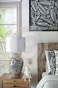 White interior in comfortable bedroom with lamp at nightstand