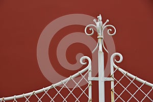 White iron fence details with red wall background