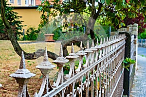 White iron fence in front of house with tree in the background in Germany.