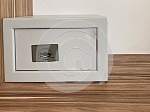 White iron small safe in the hotel room for storing valuables and money