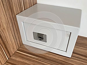 White iron small safe in the hotel room for storing valuables and money