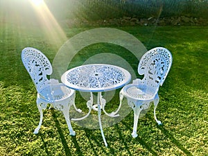 White iron table and chairs at the green field.