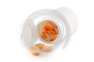 White jar with scattered orange pills on a white background. Plastic bottle for medicine, powder, tablets, tabs, capsules. Great