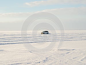 White jeep drifts on snow and ice.