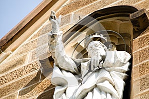 A white Jesus Christ sculpture on an old facade building.
