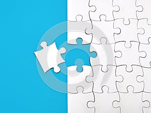 White jigsaw puzzle on blue background, top angle view