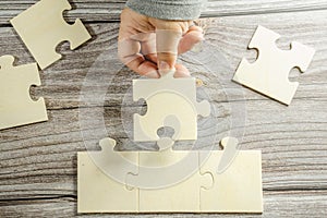 White jigsaw puzzle connecting together. Team business success partnership or teamwork concept. A group of business people