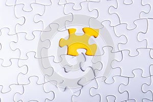 White jigsaw puzzle and missing pieces with selective focus