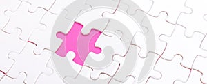 White jigsaw puzzle with with one piece missing and pink background