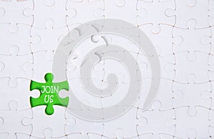 White jigsaw puzzle pattern backgroundClose up piece of white jigsaw puzzle with JOIN US text