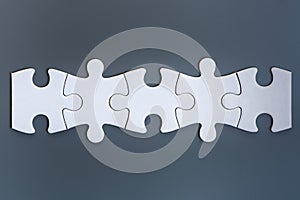 White jigsaw puzzle pieces on gray background