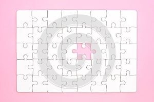 White jigsaw puzzle on pink background