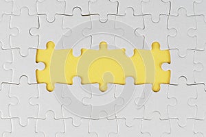 White jigsaw puzzle with two missing pieces on soft yellow. Blank missing puzzle for your creative text idea.