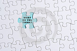 White jigsaw puzzle with words over blue background - What do you think.