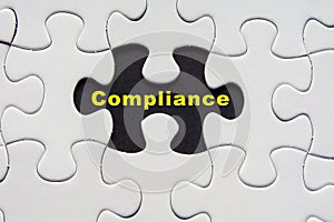 White jigsaw puzzle with a written word Compliance