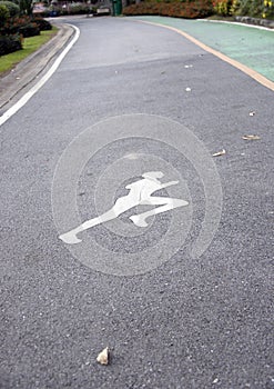 The white jogging man painting on the jogging lane parallel with green bike lane.