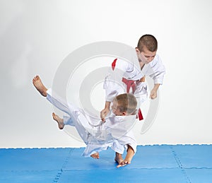 In white judogi athletes train judo throws