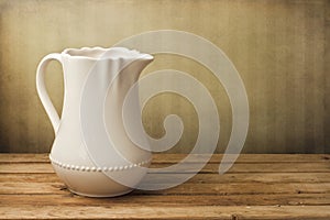 White jug on wooden table