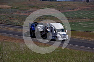 White Kenworth Semi-Truck Pulling other New Semi-Trucks photo