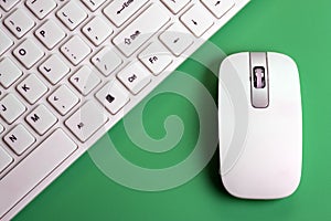 White keyboard and mouse for a computer on a green background. Wireless technology. Details close up. Copy space. The concept of