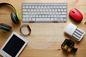 White keyboard with wireless mouse and bluetooth wireless headphones and other electronic gadgets for daily use on wooden