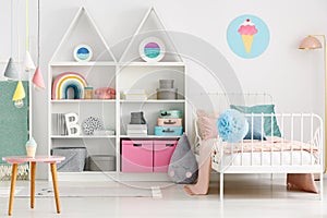 White kid`s room interior with a single bed, rainbow on the shel