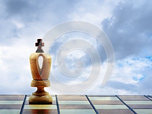 White King Chess Piece On A Chess Board Against A Cloudy Sky