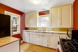 White kitchen cabinets with bright red wall