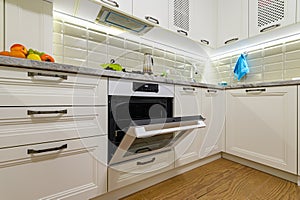 White kitchen in classic style, oven door is open