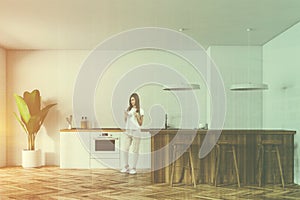 White kitchen interior with bar and stools, woman