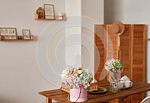 White kitchen interior in loft style. Shelves with pink crockery and kitchen utensils. Studio apartment. Rent and delivery of