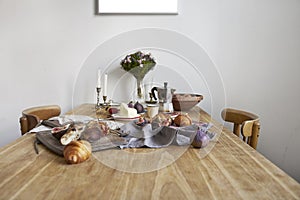 White kitchen interior with provence breakfast on wooden table, poster on the white wall, space for design layout.