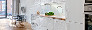 White kitchen open to dining area, panorama