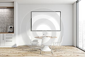 White kitchen with round table and poster