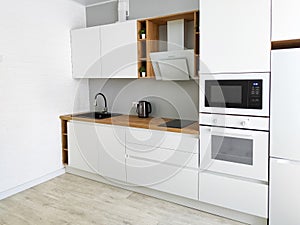 White kitchen scandinavian interior with cooker hood on wooden countertop