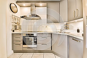 a white kitchen with stainless steel appliances and white counters