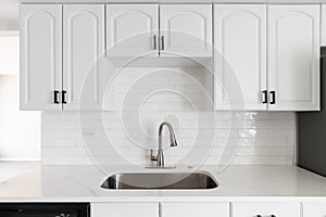 A white kitchen with a subway tile backsplash.