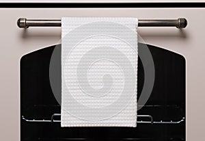 White kitchen towel hangs on the oven handle, product mockup