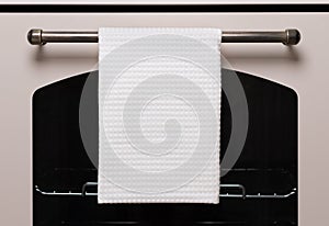 White kitchen towel hangs on the oven handle, product mockup photo
