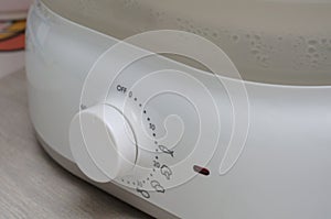 A white kitchen warmer heat heating level adjustment knob close up