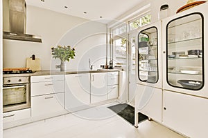 a white kitchen with white cabinets and a large window