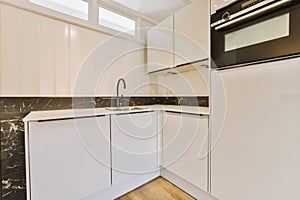 a white kitchen with white cabinets and a sink