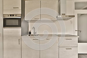 a white kitchen with white cabinets and a sink