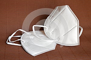 White KN95 or N95 mask for protection against coronavirus on brown background. Surgical protective mask. photo
