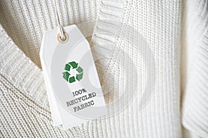 White knitted clothing with white label Recycling.