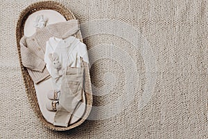 White knitted sweater, pants, jeans, shoes, wooden toys on beige background. Fashion children outfit. Top view, flat lay