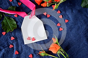 White label with a pink ribbon surrounded by little hearts and an orange rose