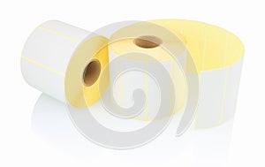 White label rolls on white background with shadow reflection. White reels of labels for printers.