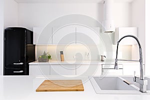 White, lacquer kitchen and black retro fridge photo