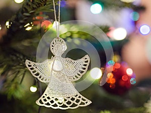 White lacy angel and red bauble. Christmas tree decorations.